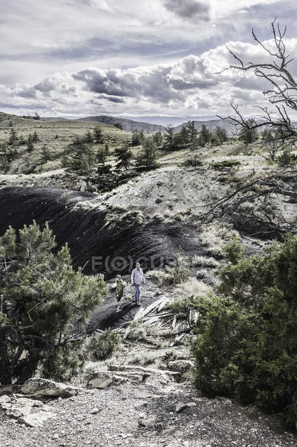 Padre e hijo caminando entre formaciones rocosas, Bridger, Montana, EE.UU. - foto de stock