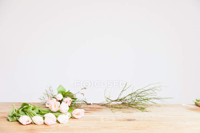 Rosarote Rosen und Zweige auf dem Tisch — Stockfoto
