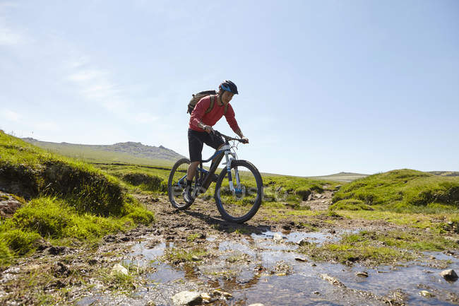 Ciclistas en bicicleta a través del agua - foto de stock