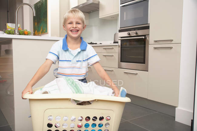 Niño llevando cesta de lavandería - foto de stock