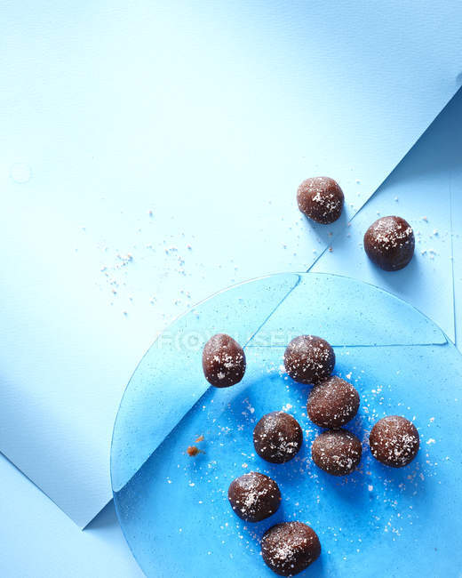 Still life of tamarind chocolate truffles on blue plate — Stock Photo