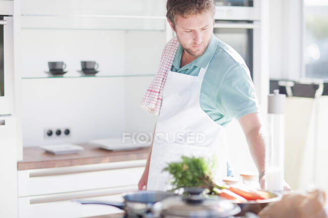 Молодий чоловік готує їжу на кухні — стокове фото
