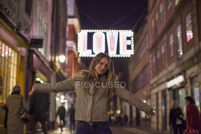 Mujer joven disfrutando de las luces de Navidad, Carnaby Street, Londres, Reino Unido - foto de stock