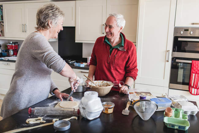 Seniorenpaar bereitet in Küche Gebäck zu — Stockfoto