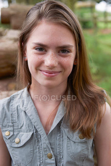 Retrato de menina adolescente sorrindo para a câmera na floresta — Fotografia de Stock