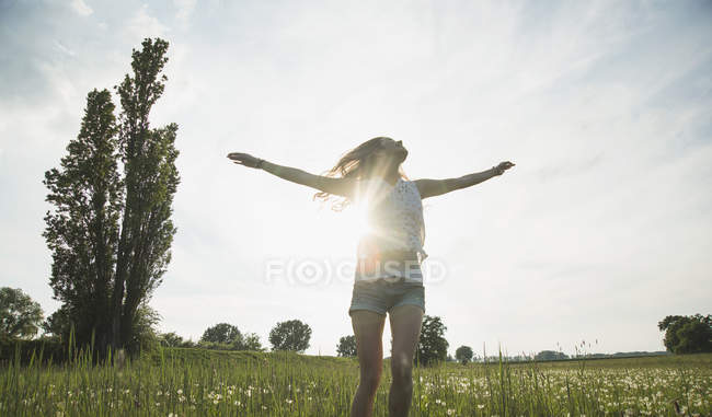 Молода жінка стрибає у полі — стокове фото