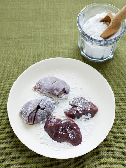 Foies de poulet recouverts de farine sur l'assiette — Photo de stock