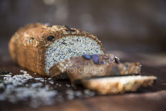 Fresh sliced seeded gluten free bread loaf on table — Stock Photo