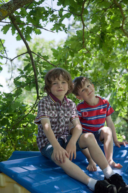 Meninos sentados no telhado da casa da árvore — Fotografia de Stock