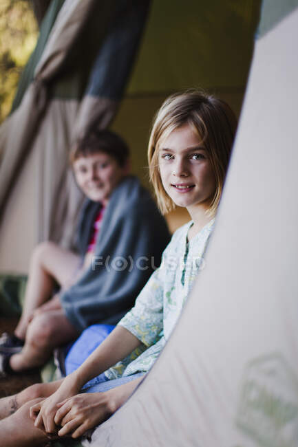 Niños sentados en tienda en el camping - foto de stock