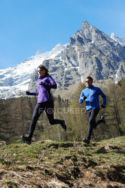 Casal adulto médio correndo, Chamonix, França — Fotografia de Stock