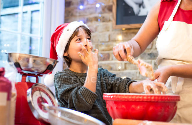 Mãe e filho fazendo biscoitos de Natal em casa — Fotografia de Stock