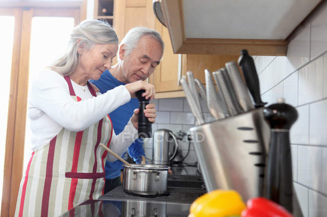 Couple plus âgé cuisiner ensemble dans la cuisine — Photo de stock