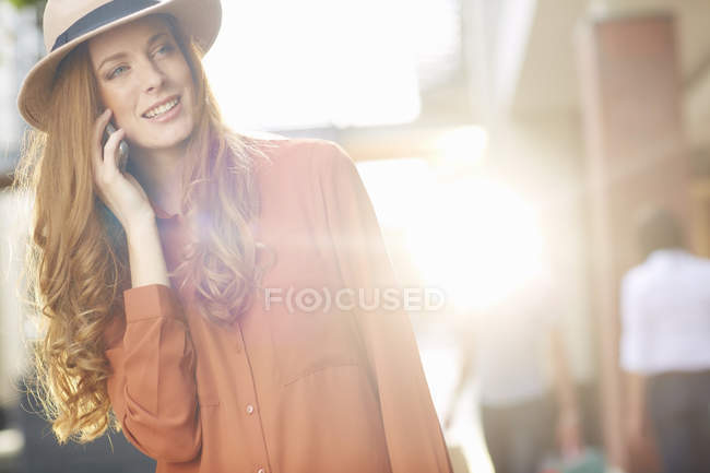 Young woman in street, using mobile phone — Stock Photo
