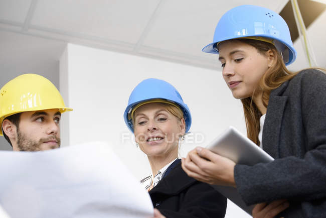 Businesswoman questioning blue print in new office building — Stock Photo