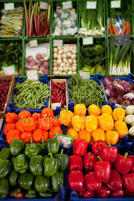 Varios pimientos y verduras que se muestran en el mercado callejero - foto de stock