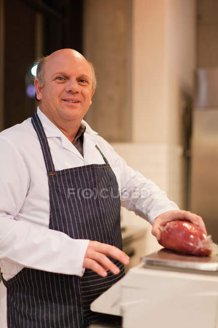 Boucher tenant morceau de viande, se concentrer sur l'avant-plan — Photo de stock