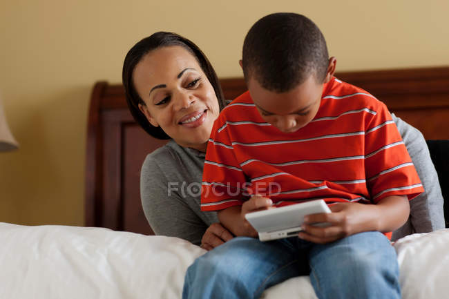 Madre e hijo jugando videojuegos - foto de stock