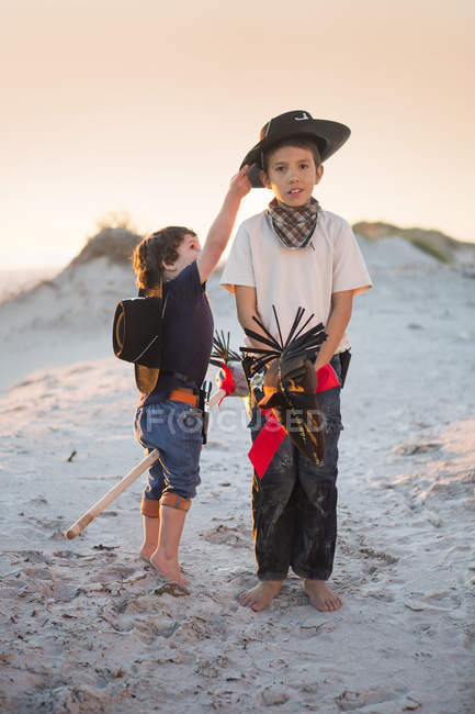 Dos hermanos vestidos de vaqueros, uno buscando sombrero - foto de stock