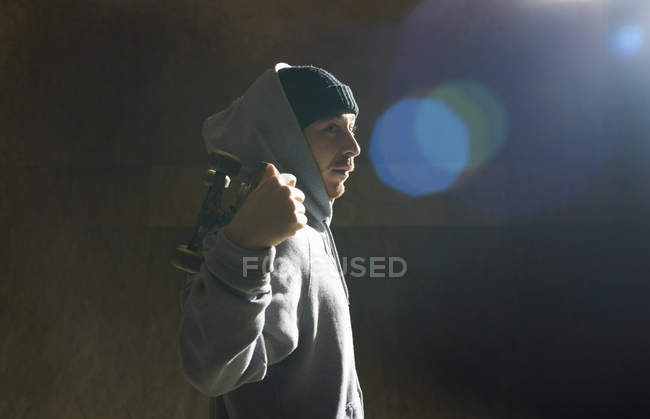 Portrait of young man holding skateboard — Stock Photo