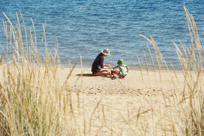 Madre e hijo jugando en la playa - foto de stock