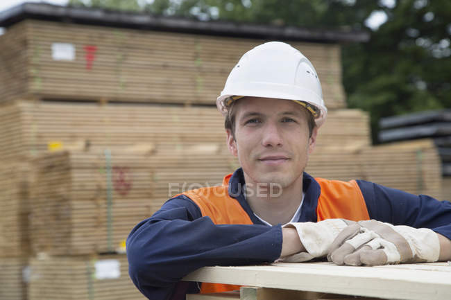 Ritratto di giovane lavoratore maschio in un cantiere di legname — Foto stock