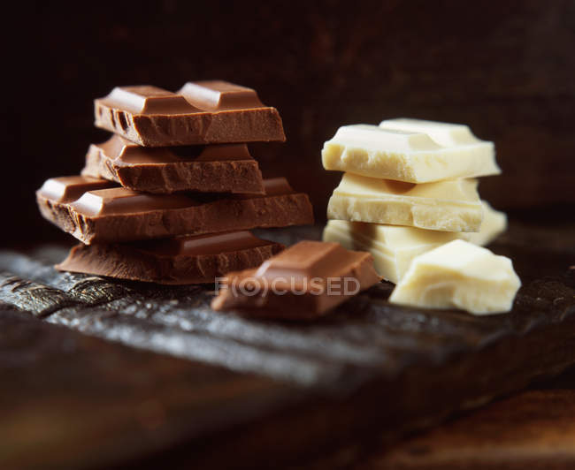 Стек молока і білого шоколаду на дерев'яній обробній дошці — стокове фото