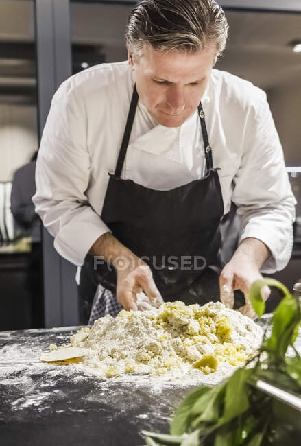 Chef miscelazione pasta gnocchi in cucina commerciale — Foto stock