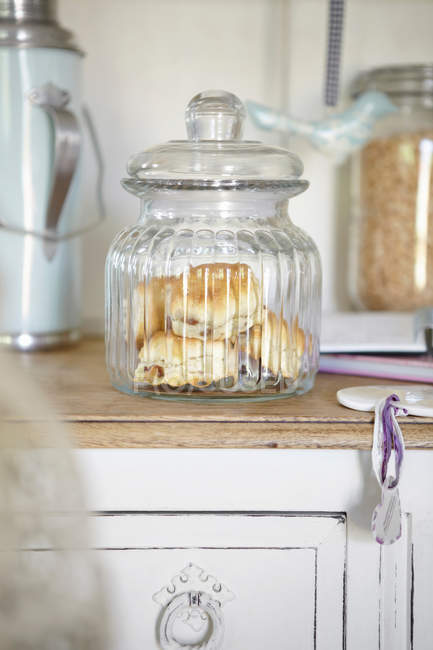 Glass jar of scones on retro kitchen counter — Stock Photo