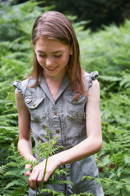 Ragazza adolescente toccando felce nella foresta — Foto stock