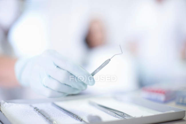 Close up of hand holding dentist instrument — Stock Photo