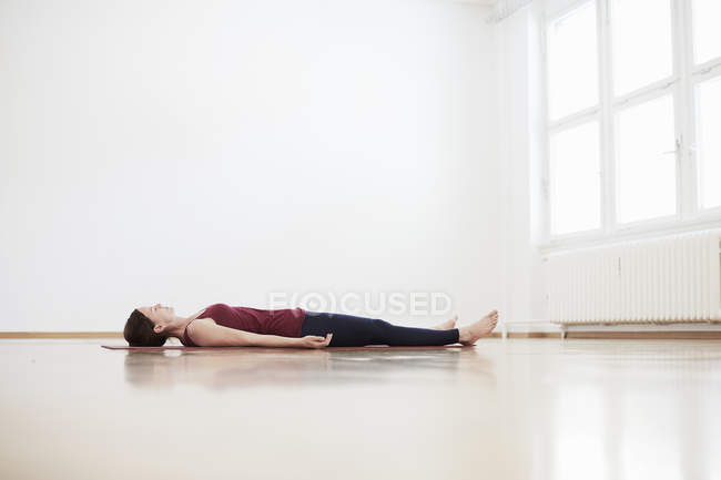 Жінка в студії вправ лежить на спині на підлозі — стокове фото