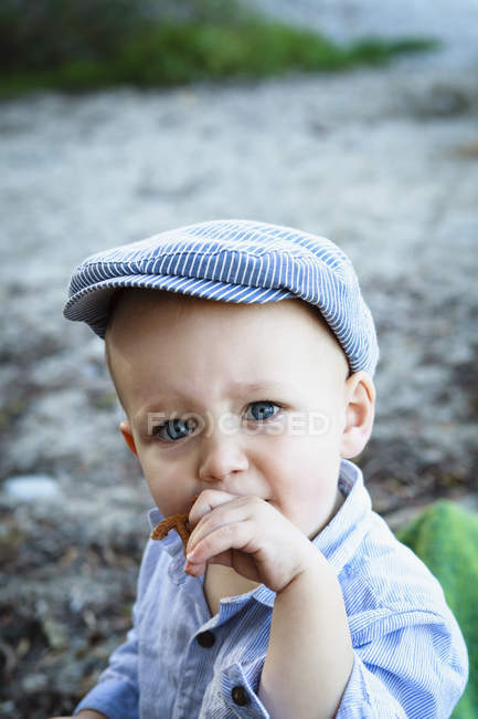 Portrait of young boy wearing flat cap, in rural setting — Stock Photo
