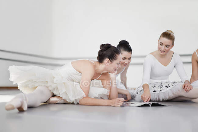 Dançarinos de balé lendo revista juntos — Fotografia de Stock