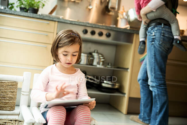 Menina usando tablet digital na cozinha — Fotografia de Stock
