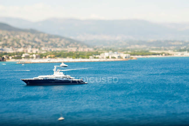 Yacht sailing by coastline — Stock Photo