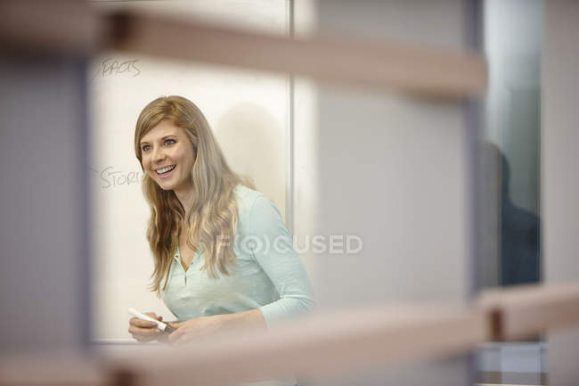 Femme d'affaires présente au tableau blanc dans le bureau — Photo de stock