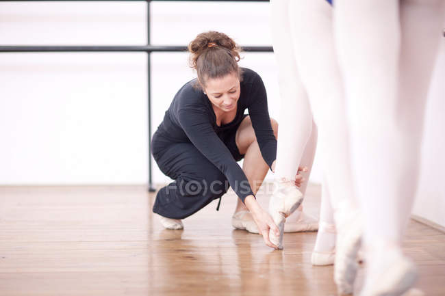 Teacher adjusting ballerinas feet pose — Stock Photo