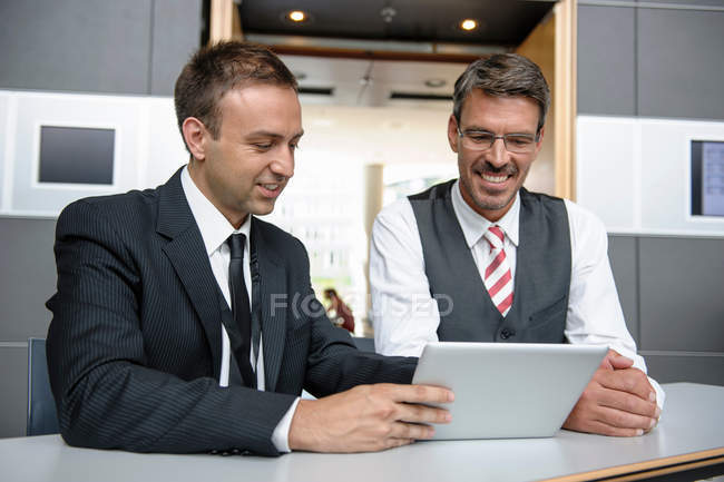 Два бизнесмена смотрят на цифровой планшет — стоковое фото
