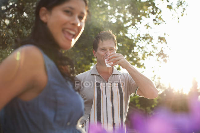 Coppia in giardino, uomo bere bicchiere d'acqua — Foto stock
