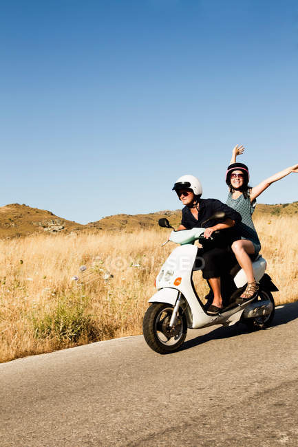 Couple scooter de conduite sur route rurale — Photo de stock