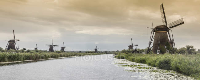 Vista à distância de Moinhos de vento e canal, Kinderdijk, Olanda, Amsterdã — Fotografia de Stock