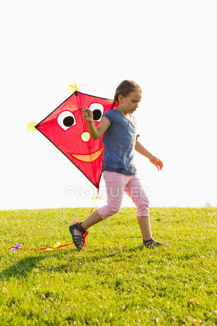 Chica jugando con cometa al aire libre - foto de stock