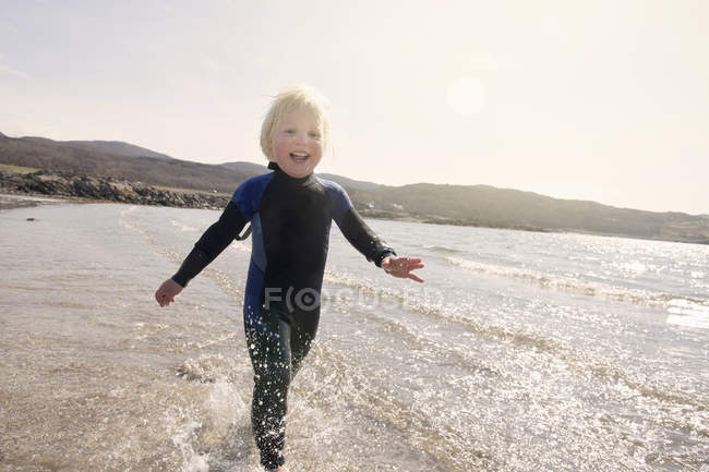 Niño corriendo en la playa, Loch Eishort, Isla de Skye, Hébridas, Escocia - foto de stock