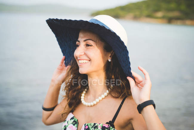 Mulher junto ao mar, usando chapéu — Fotografia de Stock