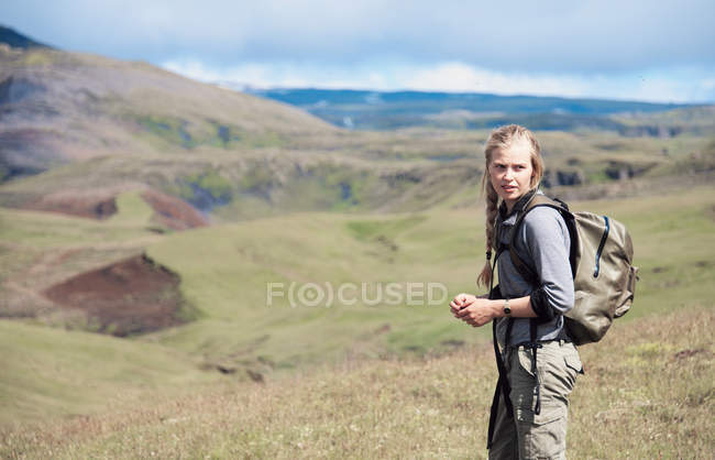 Hiker wearing backpack on hillside — Stock Photo