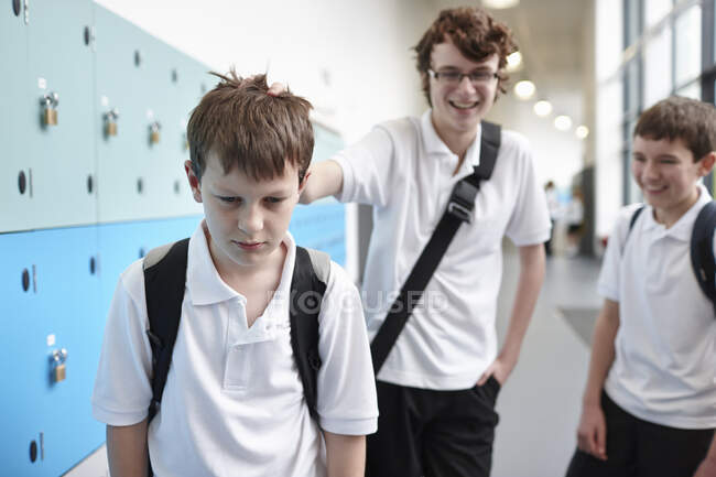 Un écolier victime d'intimidation dans un couloir scolaire — Photo de stock