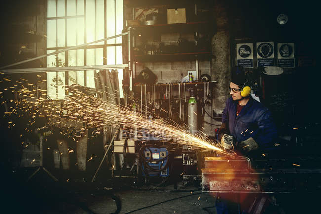 Schweißer schneidet Eisen im Werkstattinnenraum — Stockfoto