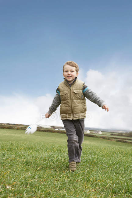 Мальчик бежит с ветряной мельницей — стоковое фото