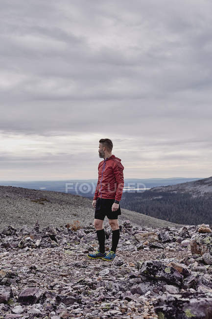 Sporty man overlooking landscape, Laponia, Finlandia - foto de stock